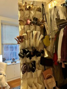 A shoe rack hanged in a door full of organized shoes.