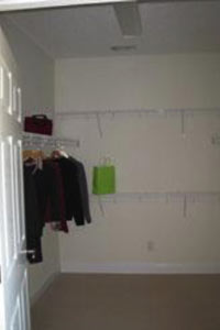 A closet with a few items on hangers A closet with a few items on hangers