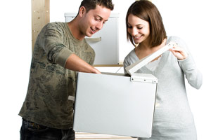 A woman and man putting an item into a box A woman and man putting an item into a box