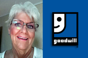 Smiling senior woman with white hair and glasses beside the Goodwill logo on a blue background.