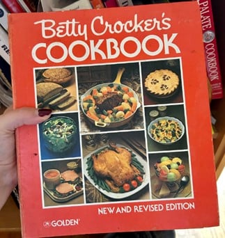 Red Betty Crocker's Cookbook cover with a collage of dishes.