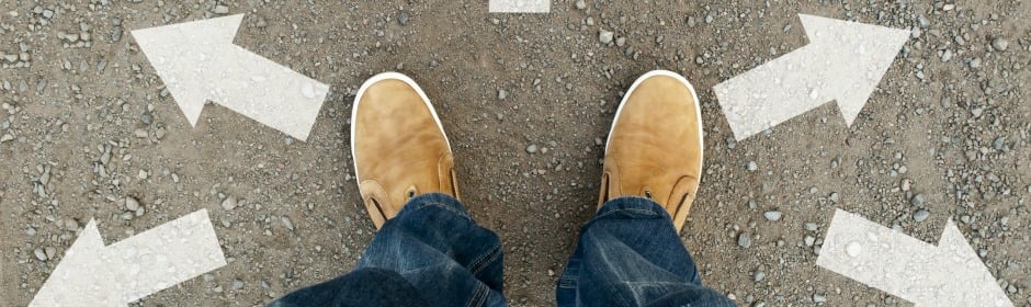 Top-down view of a person in tan boots and jeans standing on a gravel path with arrows pointing left and right.