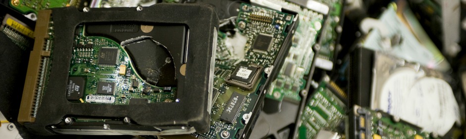 Close-up of multiple green circuit boards and electronic components inside a computer, including chips and a cracked slot frame.