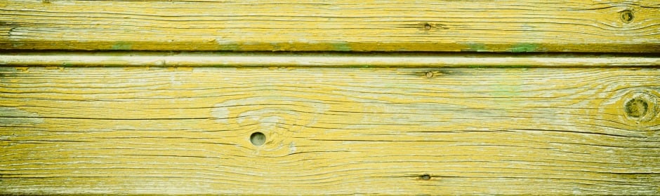 Yellow wooden planks with visible grain and knots, weathered texture.