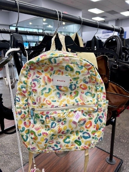 Backpack with colorful leopard print fabric hanging on a store rack