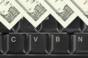 Dollar bills lay on top of keyboard