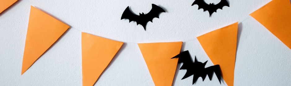 Orange pennant banner with black bat silhouettes on a light wall.