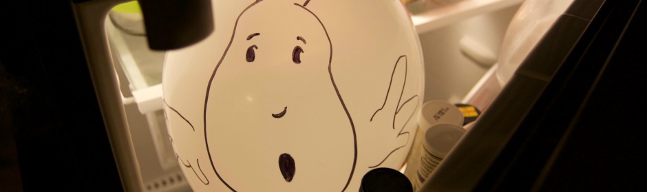 Friendly cartoon ghost drawn on a white round surface inside a fridge.