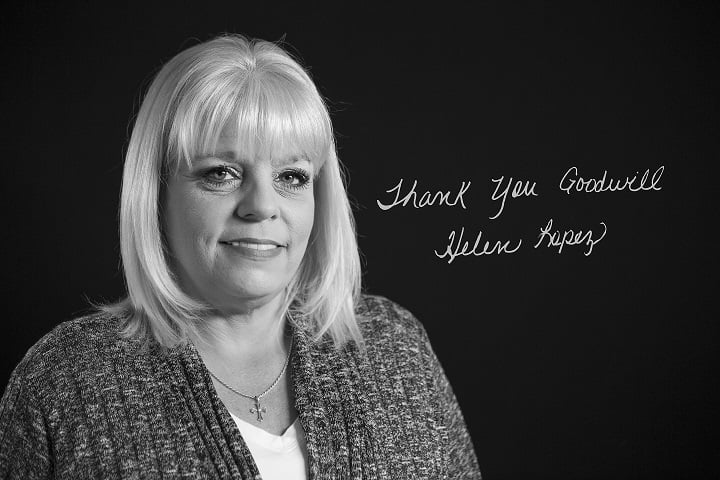 Black-and-white portrait of a smiling blonde woman with a necklace beside a handwritten Thank You Goodwill message on a dark wall.