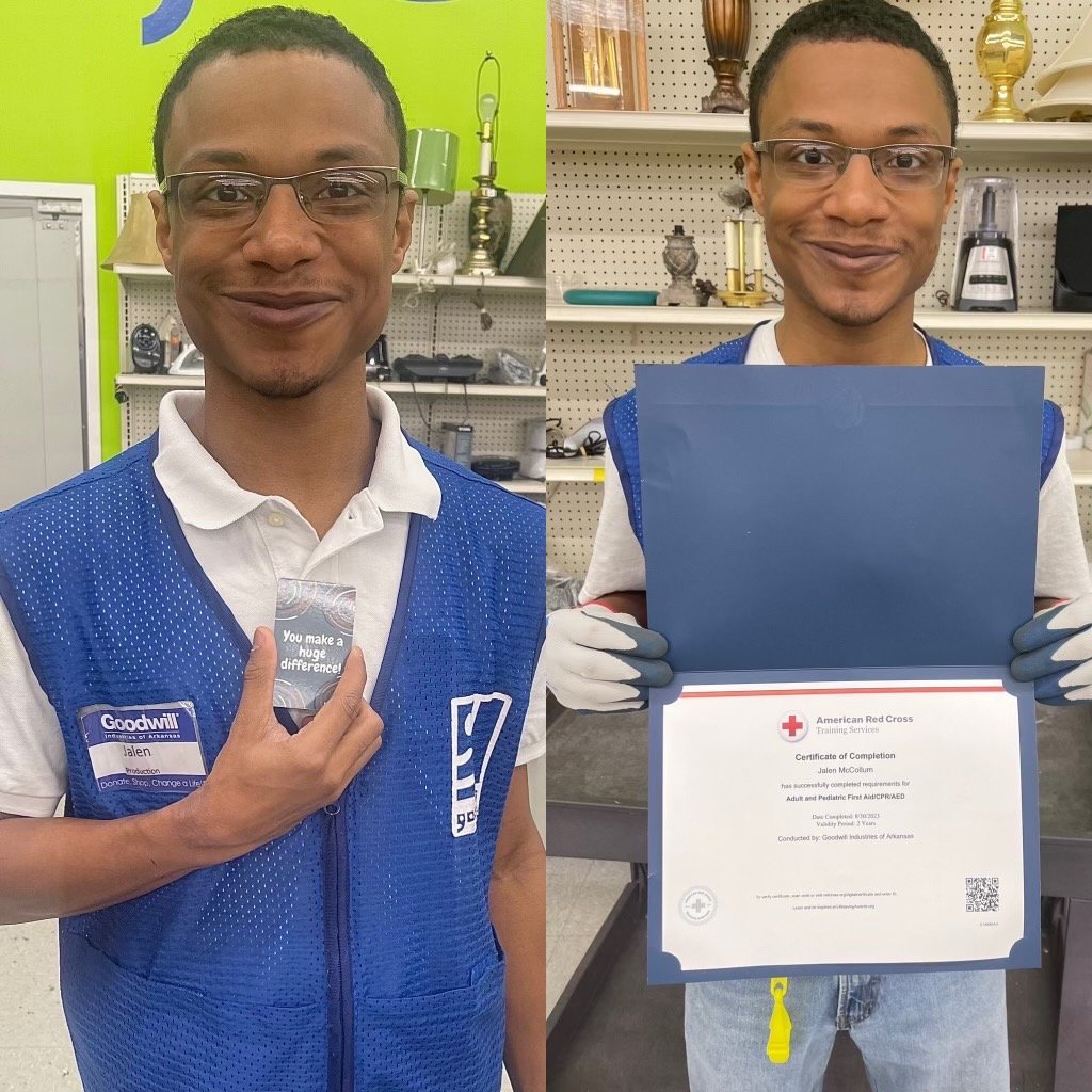 Two men in blue Goodwill vests stand in a store; one holds a certificate folder and the other a motivational card.
