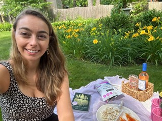 Young woman taking a selfie at a garden picnic with yellow flowers in the background