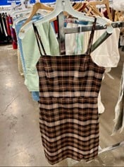 Brown plaid sleeveless dress with thin straps on a hanger in a clothing store