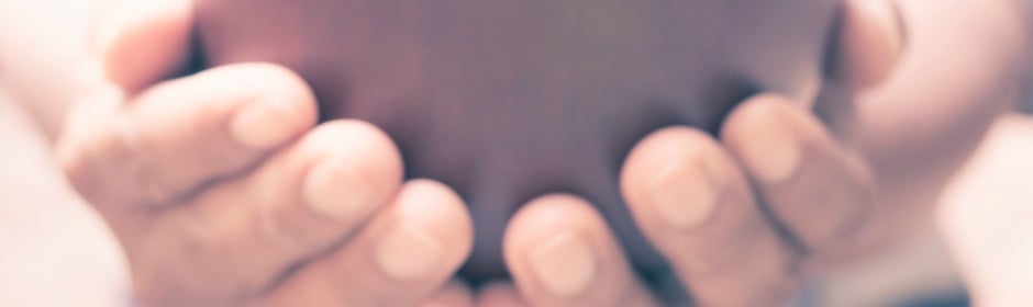 Close-up of cupped hands forming a bowl-like shape in soft warm focus.