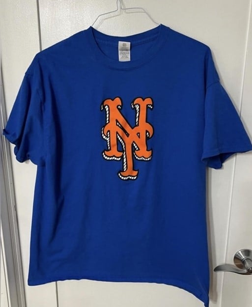 Blue T-shirt with orange interlocked NY logo on chest.