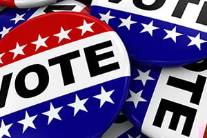 Red, white, and blue voting buttons featuring the word VOTE and white stars in a patriotic collage.