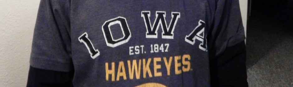 Close-up of a dark Iowa Hawkeyes T-shirt showing EST. 1847 and HAWKEYES lettering.
