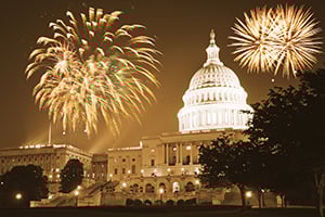 Night view of the U.S. Capitol with fireworks illuminating the sky.