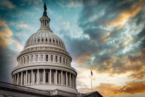 United States Capitol dome under a dramatic sunset sky.