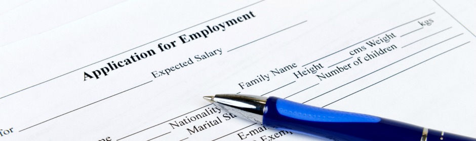 Blue fountain pen resting on an employment application form.