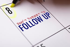 Close-up of a calendar page with a highlighted date and a bold reminder to follow up.