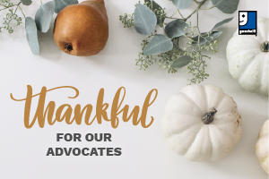 Flat lay with small white pumpkins, a pear, eucalyptus sprigs, and the text Thankful for our Advocates on a white background.