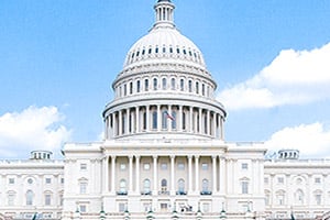 U.S. Capitol dome and neoclassical facade under a blue sky