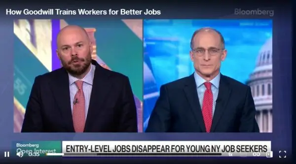 Split-screen Bloomberg interview with two anchors discussing job training; Capitol dome visible.