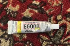 A picture of a superglue on top of a red carpet