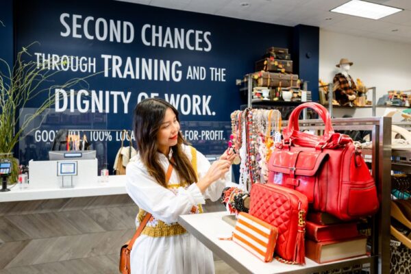 A women weating a white button down shopping a local Goodwill thrift boutique