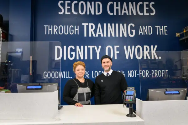 A man and a women standing in front of a walk saying Second Chance, Training and the Dignity of Work