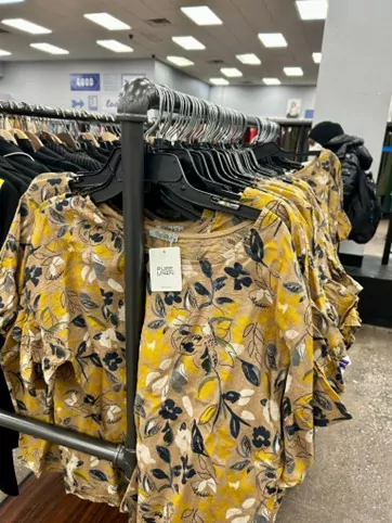 Yellow blouses hanging in a store rack