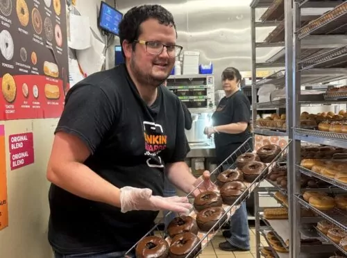 Picture of a young adult wearing reading glasses at a donut store
